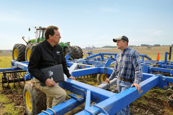 An agent out on the farm with a customer.